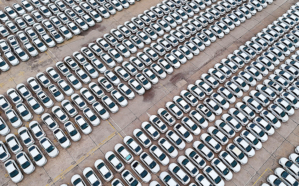 Många långa rader av nya bilar på en parkering i Kina