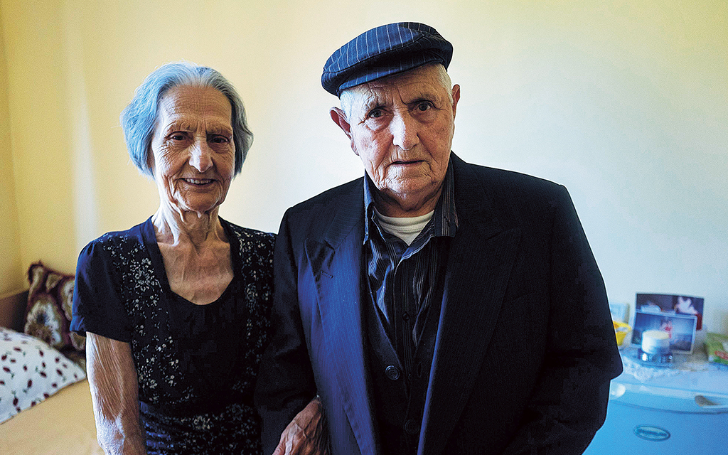 Två äldre, albanska syskon tittar in i kameran.