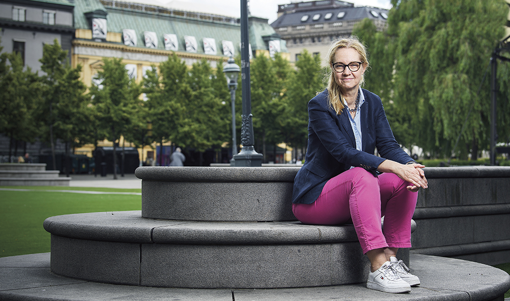 Cecilia Skingsley sitter på en mur i en grön park i Basel