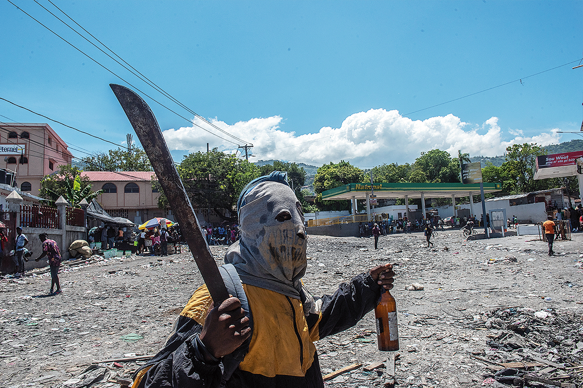 Maskerad man med machete under en protest i Haitis huvudstad Port-au-Prince.