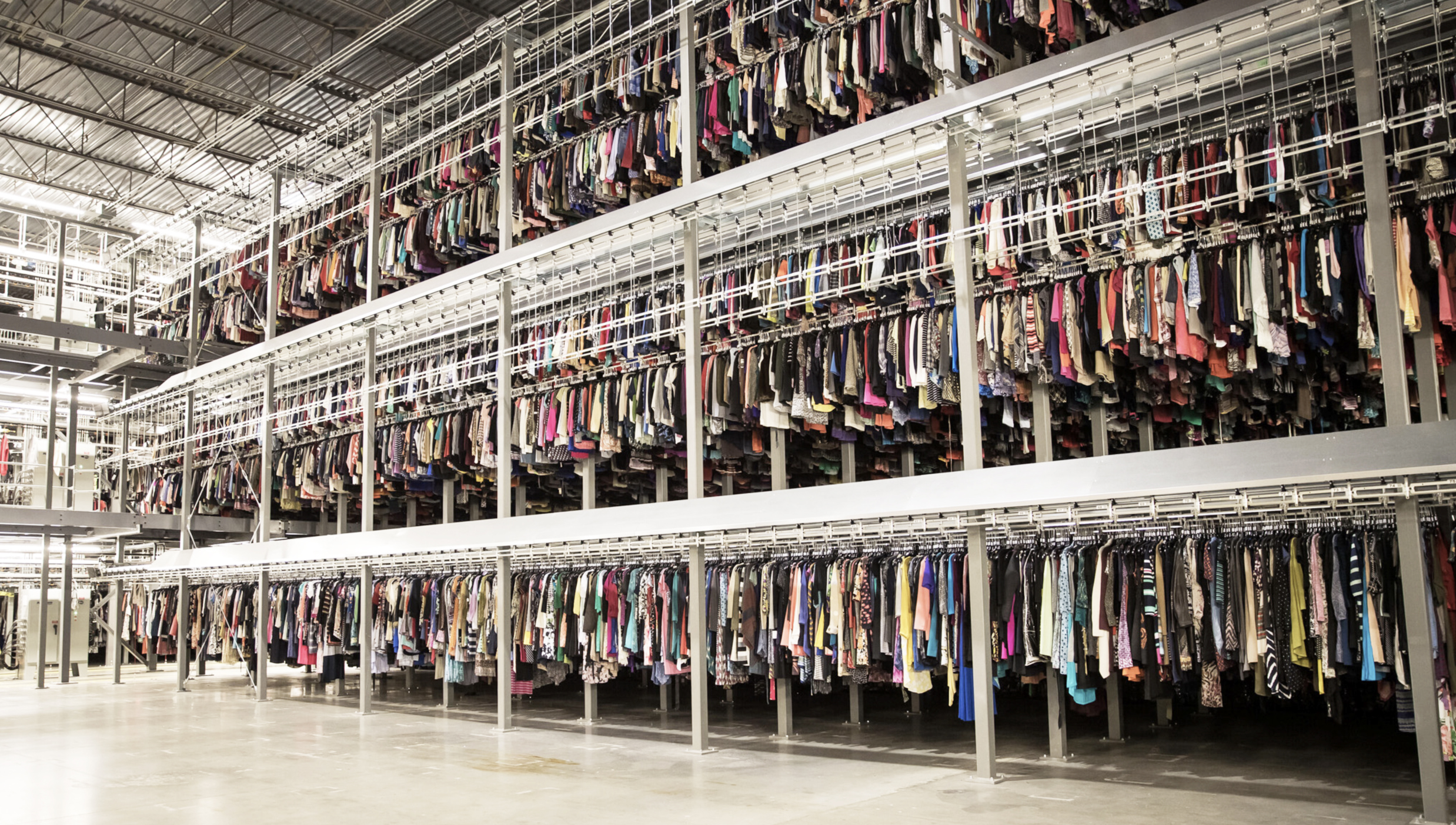 Kläder på rad i en gigantisk lagerlokal hos företaget TredUP