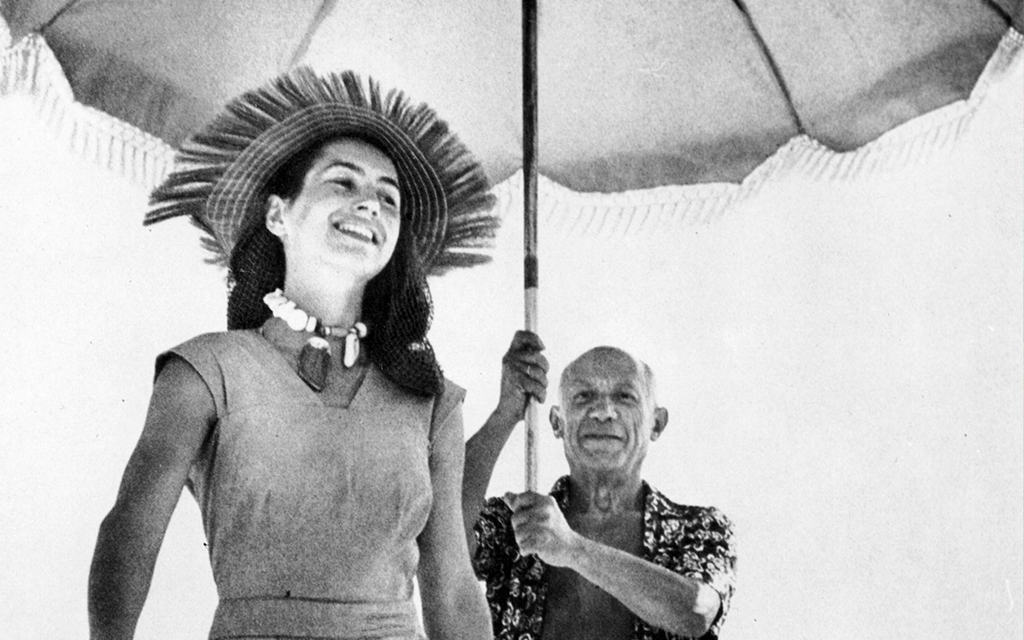 Picasso håller ett parasoll ovanför huvudet på sin partner Françoise Gilot.