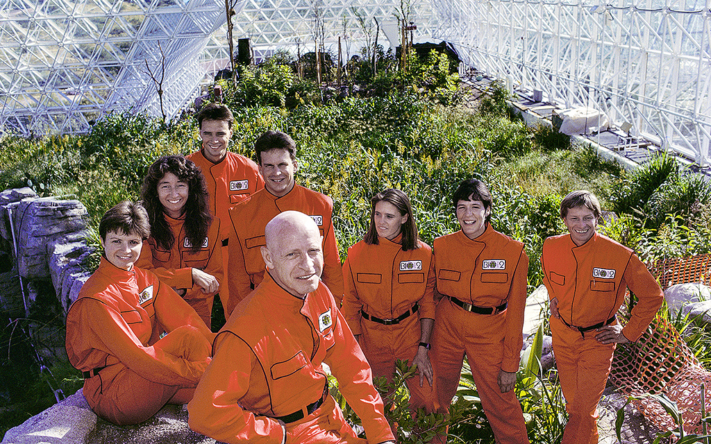 Biosphere 2-deltagarna uppställda framför kameran i ett växthus