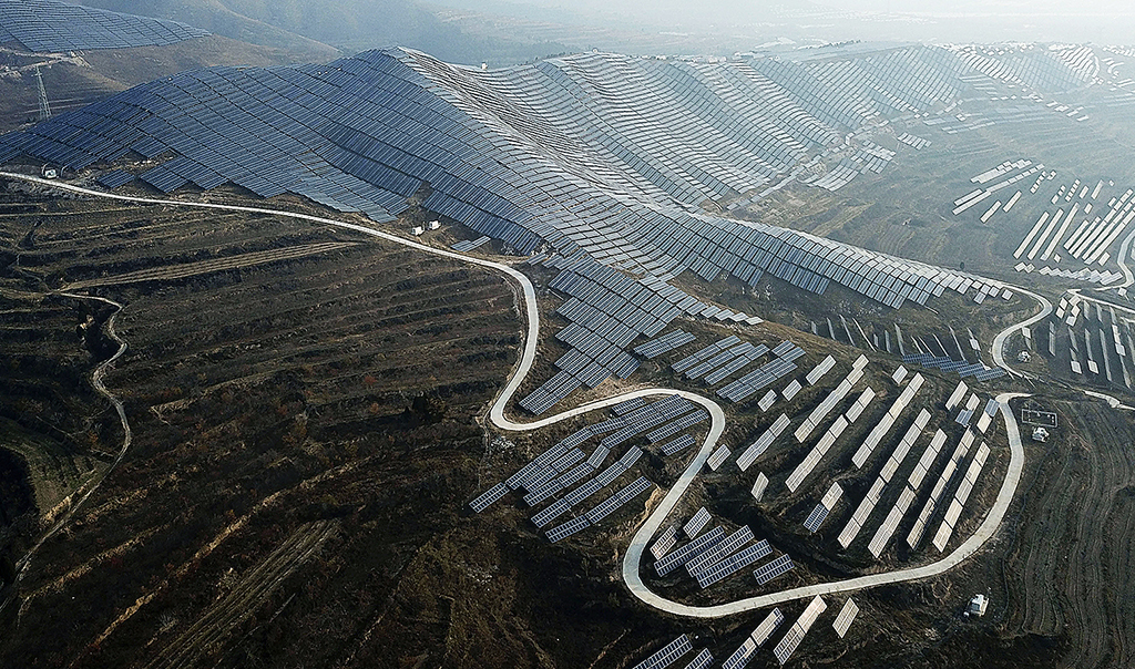Flygfoto över ett böljande landskap med solceller i Kina.