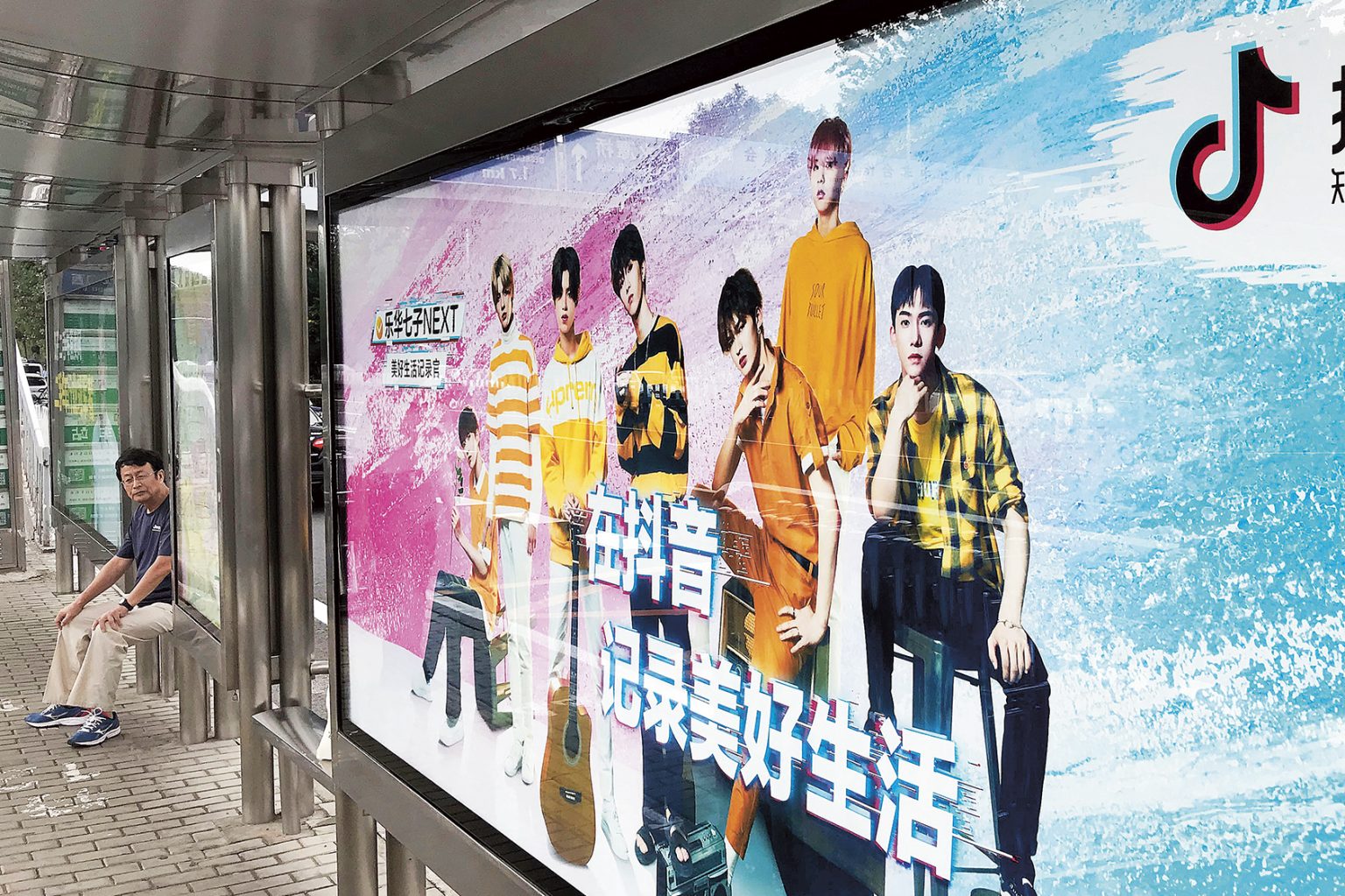 BIllboardtavla vid en kollektivtrafikhållplats i Kina. På tavlan syns en reklam för TikTok