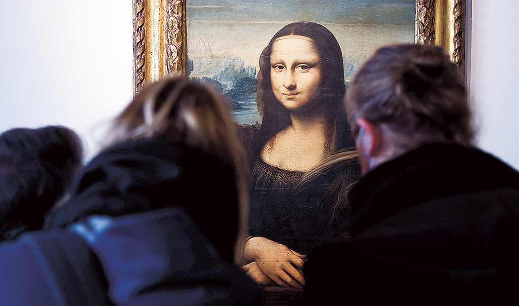 Två kvinnor i förgrunden betraktar konstverket Mona Lisa
