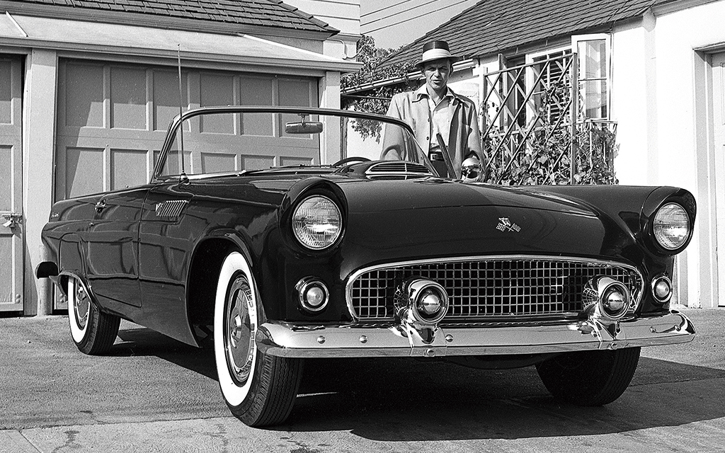 Amerikanske Hollywoodikonen Frank Sinatra poserar framför sin Ford Thunderbird från 1955