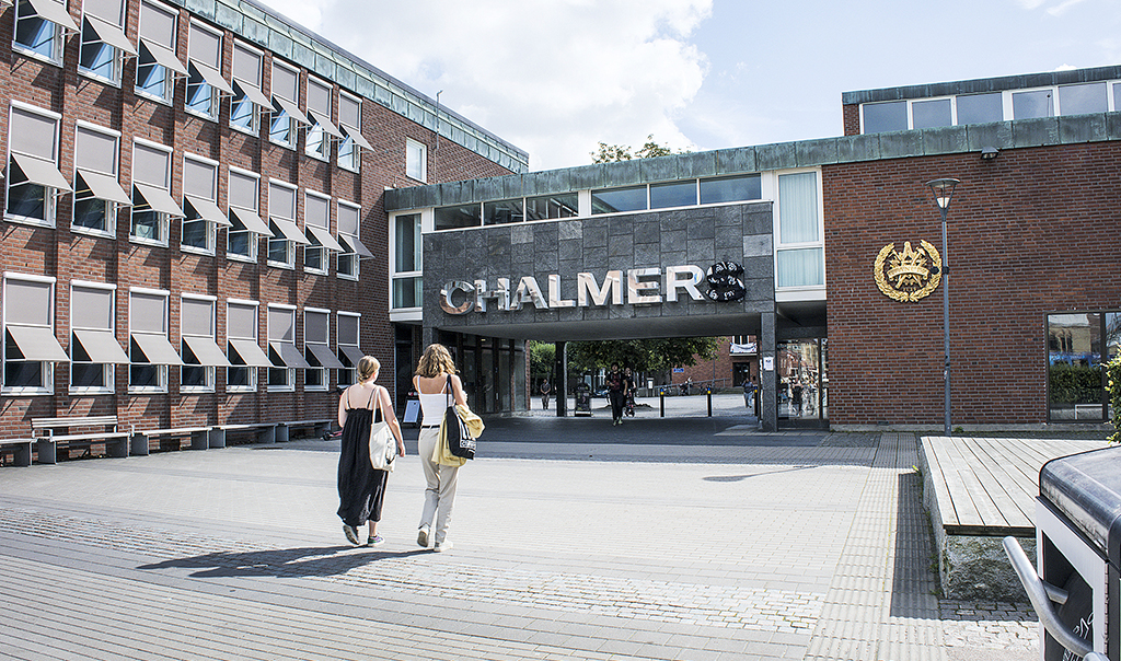 Två unga sommarklädda kvinnor går mot Chalmers entré