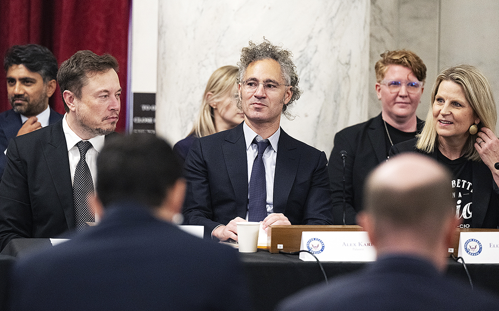 Årets vd Alex Karp sitter vid ett talarbord tillsammans med med Elon Musk och Elizabeth Shuler, på ett tvärpolitiskt AI-forum i Washington.