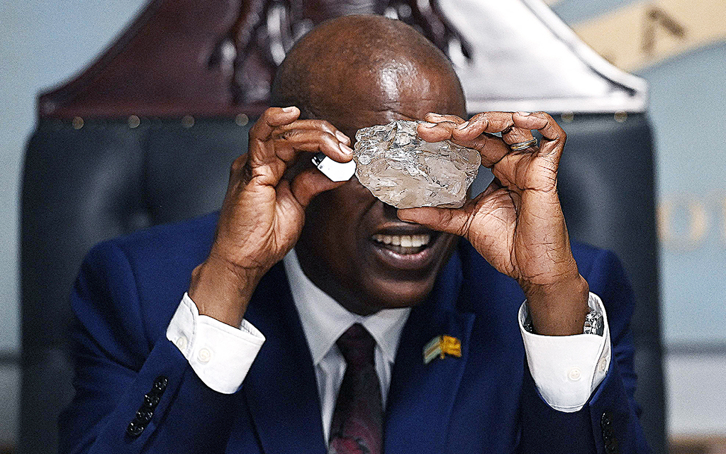 Botswanas president Mokgweetsi Masisi inspekterar en jättediamant med förstoringsglas