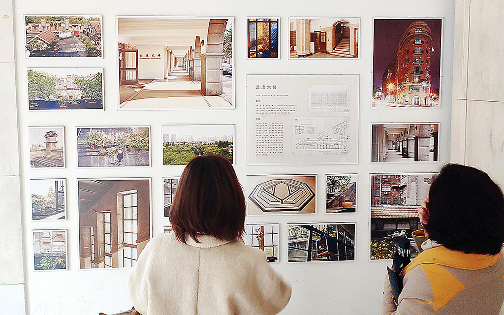 Fastighetskris. Två kvinnor står och tittar på bilder från ett nyrenoverat bostadshus i Kina.