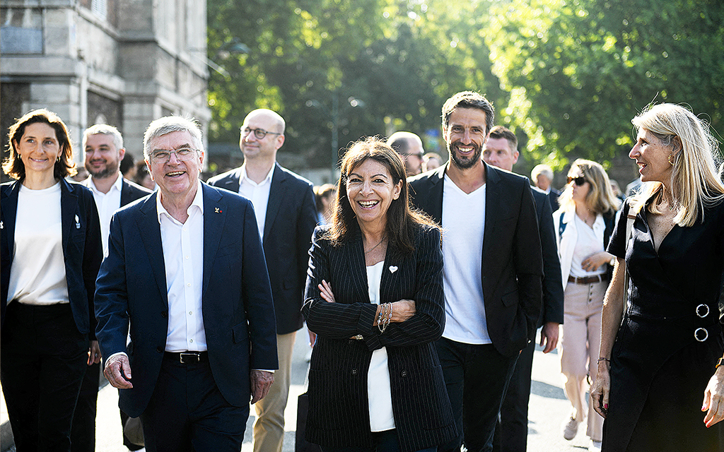 Paris borgmästare Anne Hidalgo promenerar i en klunga av människor.
