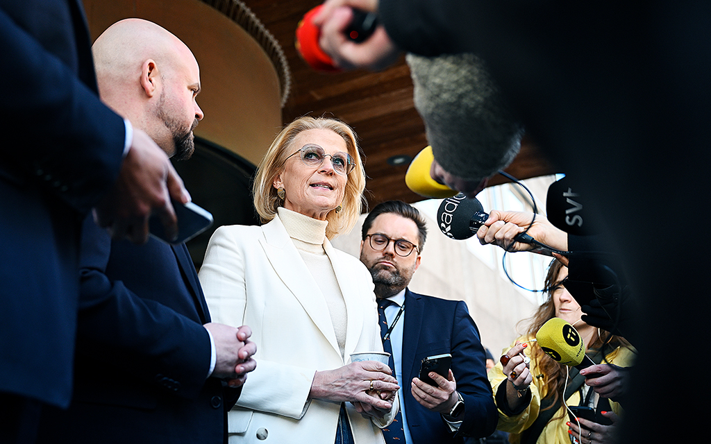 Finansminister Elisabeth Svantesson står och pratar in i en mikrofon omgiven av ett antal reportrar