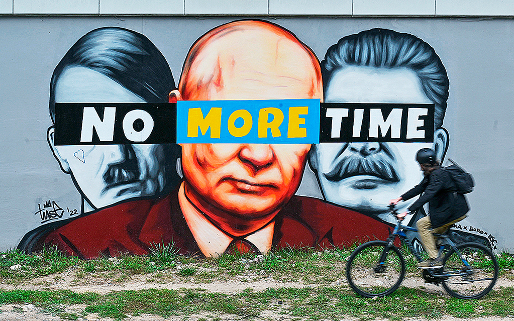 Muralmålning påmen vägg i Gdansk föreställande Hitler, Putin och Stalin. Över deras ögon står texten 