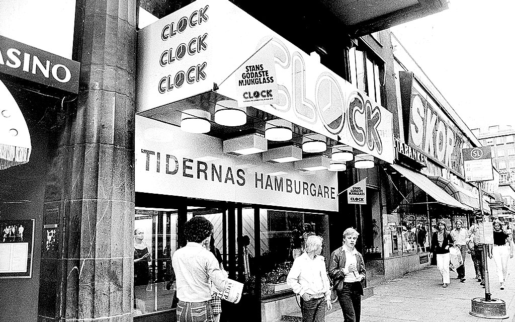 Svartvitt foto av en hamburgerrestaurang med skylten 'Tidernas Hamburgare'.